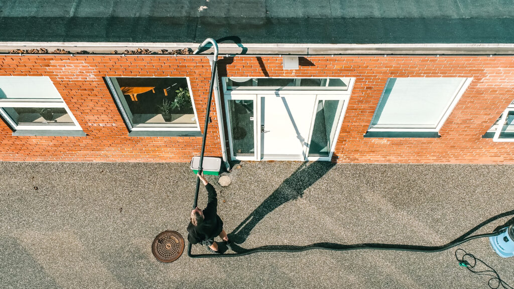 Medarbejder fra Anders Andersens Rengøring udfører tagrenderens