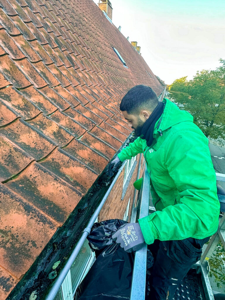 Medarbejder fra Anders Andersens Rengøring udfører tagrenderens