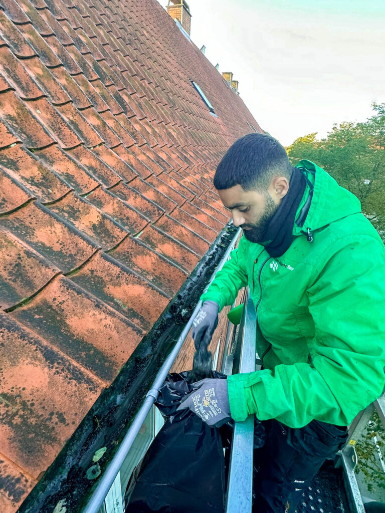 Medarbejder fra Anders Andersens Rengøring udfører tagrenderens