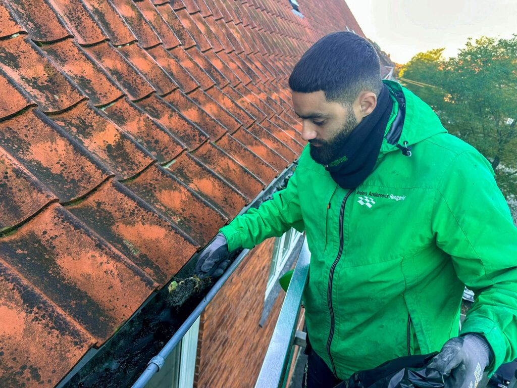 Medarbejder fra Anders Andersens Rengøring udfører tagrenderens