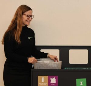 Melanie Weilguny, Bæredygtighedsansvarlig hos Anders Andersen rengøring, ved siden af vores affaldssorteringssystem.